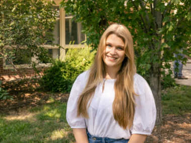 Headshot of Lauren Fisher. Outdoors, wearing a white blouse.