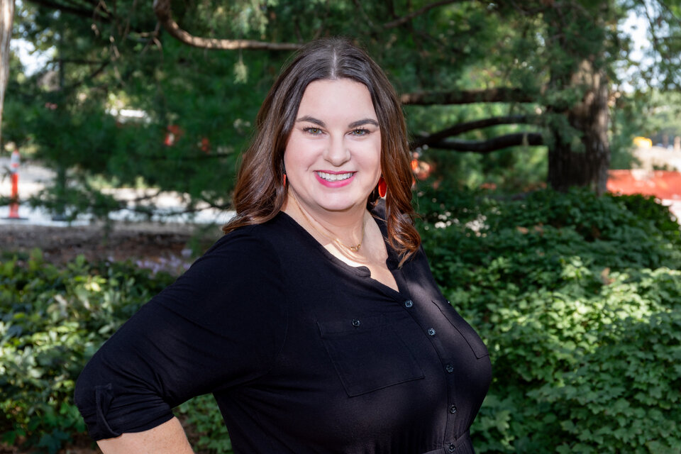 Headshot of Jamie Buhrman. Outdoors, wearing a black blouse.