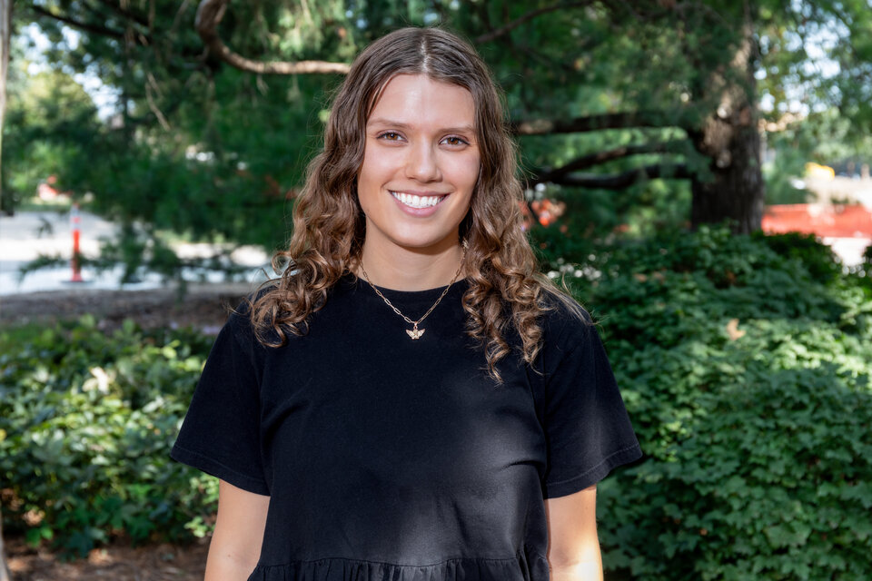 Headshot of Katie Woodward. Outdoors, wearing a black blouse.