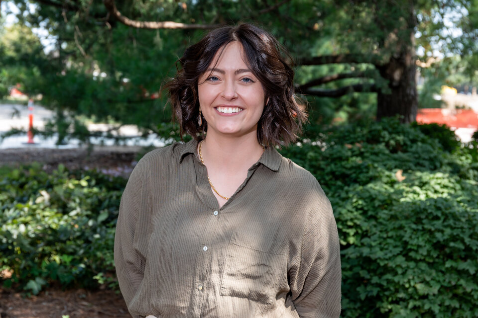 Headshot of Stephanie Kozol. Outdoors, wearing a moss green blouse.